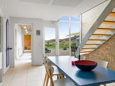 a dining room with a blue table and a staircase at Holiday Home Tinea - 50m from the sea by Interhome in Pandrup