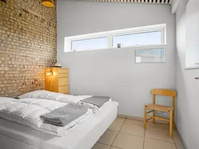 a white bedroom with a bed and a window at Holiday Home Tinea - 50m from the sea by Interhome in Pandrup