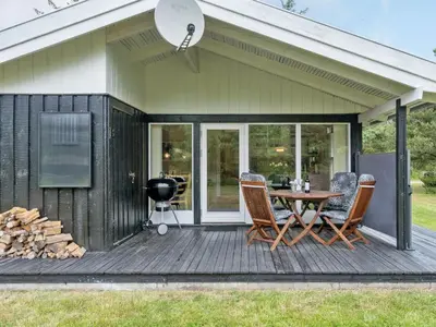 a deck with a table and chairs on it at Holiday Home Svantepolk - 1-1km from the sea by Interhome in Pandrup