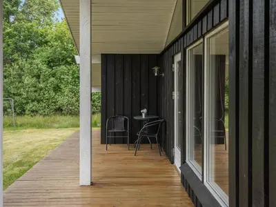 a porch with a table and chairs on it at Holiday Home Evan - 1-3km from the sea by Interhome in Pandrup