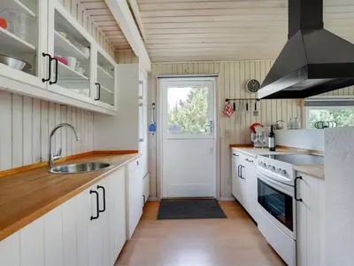 a kitchen with white cabinets and a sink at Holiday Home Evan - 1-3km from the sea by Interhome in Pandrup