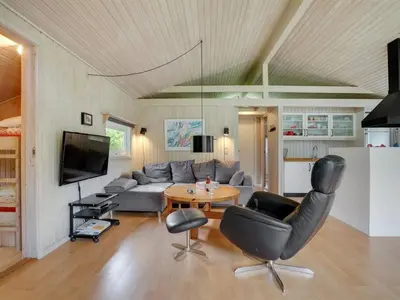 a living room with a couch and a table and chairs at Holiday Home Evan - 1-3km from the sea by Interhome in Pandrup
