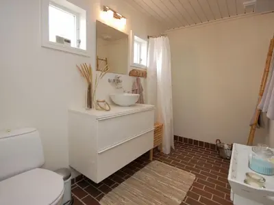 a bathroom with a white sink and a toilet at Holiday Home Frieda - 7-2km from the sea by Interhome in Pandrup