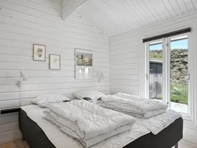 two beds in a white room with a window at Holiday Home Baltur - 650m from the sea by Interhome in Saltum