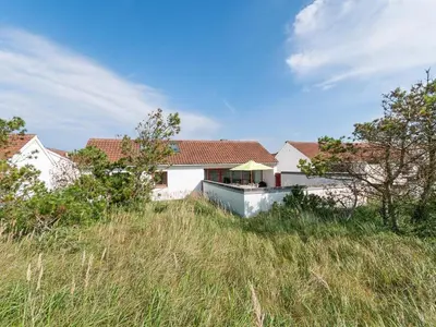 a white house on top of a grassy hill at Holiday Home Ara - 700m from the sea by Interhome in Pandrup