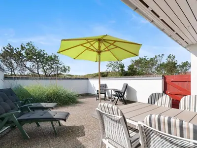 a patio with a table with a yellow umbrella at Holiday Home Ara - 700m from the sea by Interhome in Pandrup