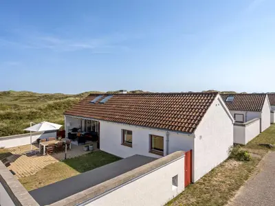 a white house with a roof with a patio at Holiday Home Marjon - 400m from the sea by Interhome in Pandrup