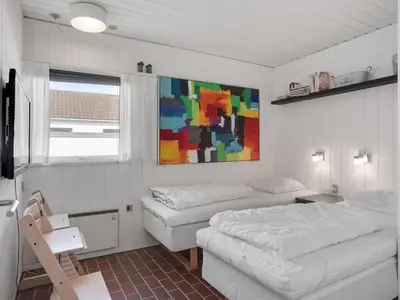 a bedroom with two beds and a painting on the wall at Holiday Home Marjon - 400m from the sea by Interhome in Pandrup