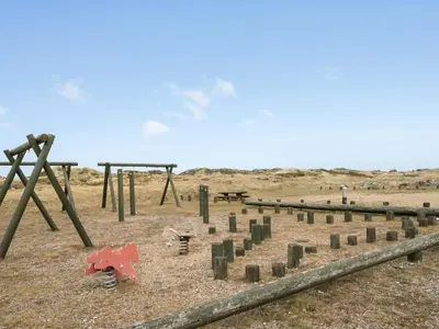 a playground in a field with trees and swings at Holiday Home Emiljan - 400m from the sea by Interhome in Pandrup