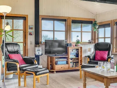 a living room with two chairs and a television at Holiday Home Marite - 200m from the sea by Interhome in Pandrup