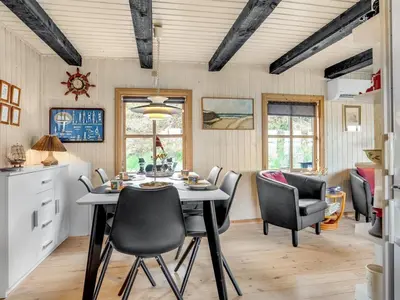 a kitchen and dining room with a table and chairs at Holiday Home Marite - 200m from the sea by Interhome in Pandrup