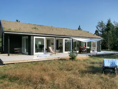 a house with a large deck with a porch at Holiday Home Melinda - 2km from the sea by Interhome in Pandrup