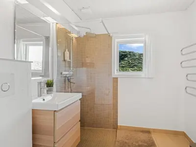 a white bathroom with a sink and a window at Holiday Home Ingomar - 300m from the sea by Interhome in Pandrup