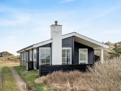 a black and white house on the side of a road at Holiday Home Zaharinka - 300m from the sea by Interhome in Pandrup