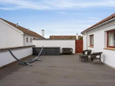 a patio with chairs and a couple of buildings at Holiday Home Viena - 400m from the sea by Interhome in Pandrup