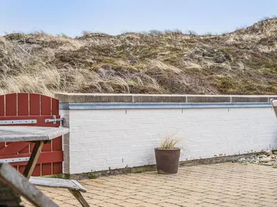 a brick wall with a plant next to a bench at Holiday Home Viena - 400m from the sea by Interhome in Pandrup