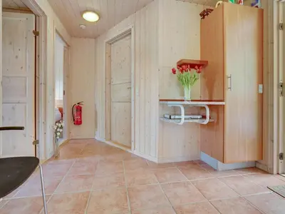 a hallway with a door and a vase of flowers at Holiday Home Krister - 250m to the fjord by Interhome in Farsø