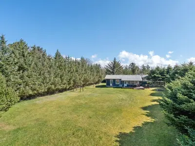 a house in the middle of a field with trees at Holiday Home Josefiina - 450m to the fjord by Interhome in Løgsted