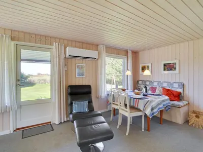 a dining room with a table and chairs and a window at Holiday Home Josefiina - 450m to the fjord by Interhome in Løgsted