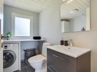 a bathroom with a sink and a washing machine at Holiday Home Josefiina - 450m to the fjord by Interhome in Løgsted