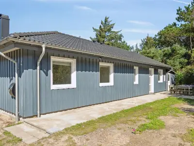 a blue building with white windows at Holiday Home Awenita - 50m to the fjord by Interhome in Løgsted