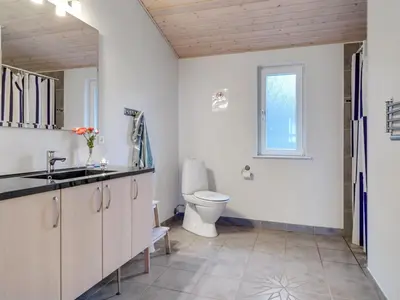 a bathroom with a toilet and a sink at Holiday Home Awenita - 50m to the fjord by Interhome in Løgsted