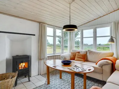 a living room with a couch and a fireplace at Holiday Home Githa - 100m to the fjord by Interhome in Løgstør