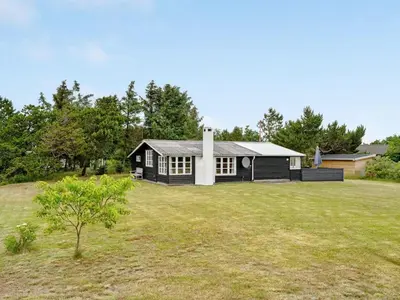 a black and white house with a yard at Holiday Home Githa - 100m to the fjord by Interhome in Løgstør