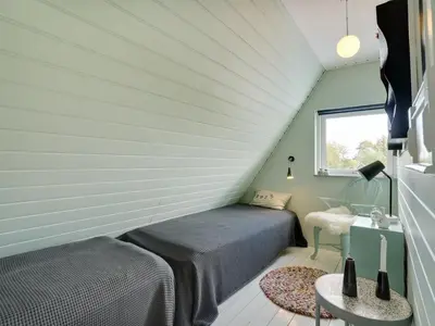 a bedroom with two beds and a table in a room at Holiday Home Tamer - 500m to the fjord by Interhome in Farsø