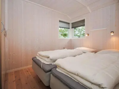 two beds in a white room with a window at Holiday Home Evelina - 150m to the fjord by Interhome in Løgsted