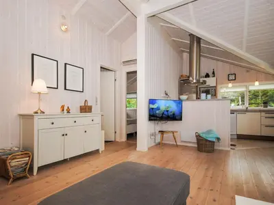 a living room with a tv and a kitchen at Holiday Home Evelina - 150m to the fjord by Interhome in Løgsted