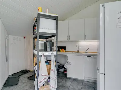 a kitchen with white cabinets and a refrigerator at Holiday Home Marlien - 1km to the fjord by Interhome in Løgsted