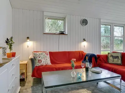a living room with a red couch and a table at Holiday Home Marlien - 1km to the fjord by Interhome in Løgsted