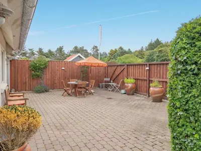 a patio with an umbrella and a table and chairs at Holiday Home Yorrick - 50m to the fjord by Interhome in Løgstør