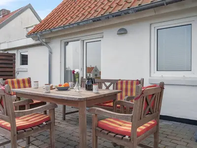 a wooden table and chairs on a patio at Holiday Home Yorrick - 50m to the fjord by Interhome in Løgstør