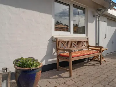 a bench sitting under a window next to a flower pot at Holiday Home Yorrick - 50m to the fjord by Interhome in Løgstør