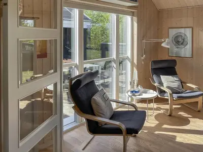 a living room with two chairs and a table at Holiday Home Eireen - 600m to the fjord by Interhome in Farsø