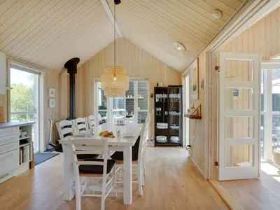 a dining room with a white table and chairs at Holiday Home Eireen - 600m to the fjord by Interhome in Farsø