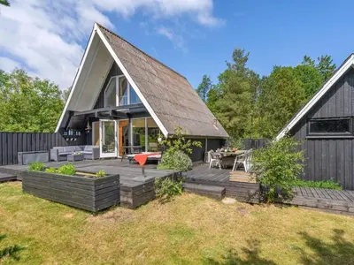 a home with a gambrel roof and a deck at Holiday Home Jütte - 2km to the fjord by Interhome in Farsø