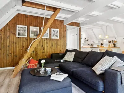 a living room with a blue couch and wooden walls at Holiday Home Jütte - 2km to the fjord by Interhome in Farsø