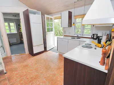 a kitchen with white cabinets and a tile floor at Holiday Home Gesina - 600m to the fjord by Interhome in Løgstør