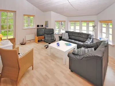 a living room with a couch and a table at Holiday Home Gesina - 600m to the fjord by Interhome in Løgstør