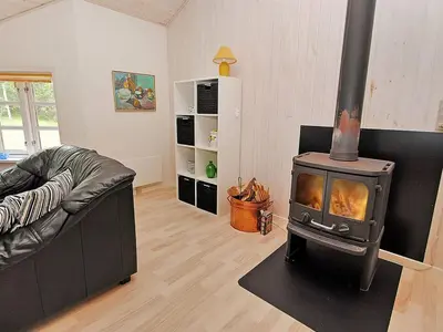a living room with a fireplace and a couch at Holiday Home Gesina - 600m to the fjord by Interhome in Løgstør
