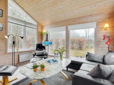 a living room with a table and a couch at Holiday Home Magh by Interhome in Års