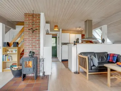 a living room with a fireplace and a stove at Holiday Home Valo - 400m to the fjord by Interhome in Løgsted