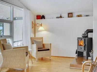 a living room with a wood stove and chairs at Holiday Home Freda - 100m to the fjord by Interhome in Løgsted
