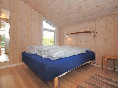 a bedroom with a blue bed in a room with a window at Holiday Home Einette - 3-5km from the sea by Interhome in Fjerritslev