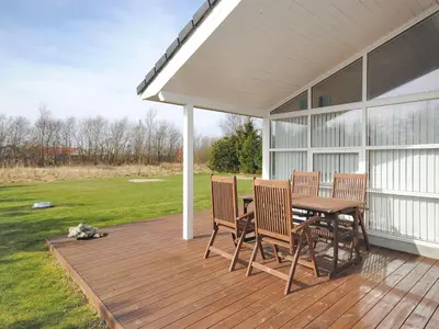 a wooden deck with a table and chairs on a house at Holiday Home Einette - 3-5km from the sea by Interhome in Fjerritslev