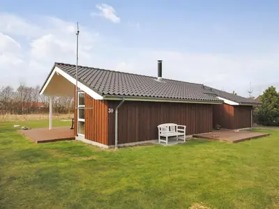 a small building with a bench in a yard at Holiday Home Einette - 3-5km from the sea by Interhome in Fjerritslev