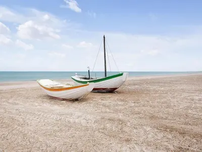 two boats are sitting on a sandy beach at Holiday Home Einette - 3-5km from the sea by Interhome in Fjerritslev
